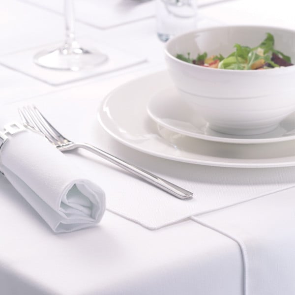 White polyester table linen laid with a napkin, cutlery and tableware